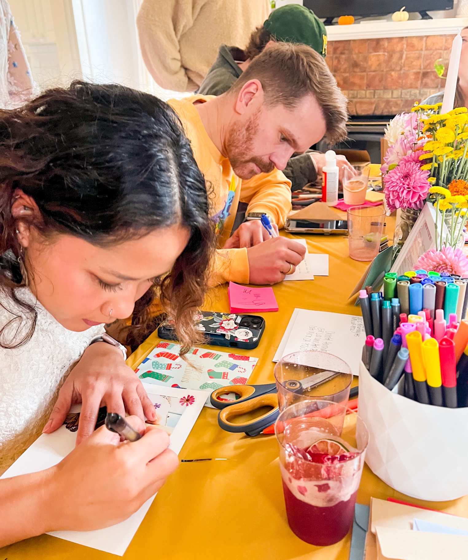 Guests writing heartfelt cards with cocktails and colorful pens